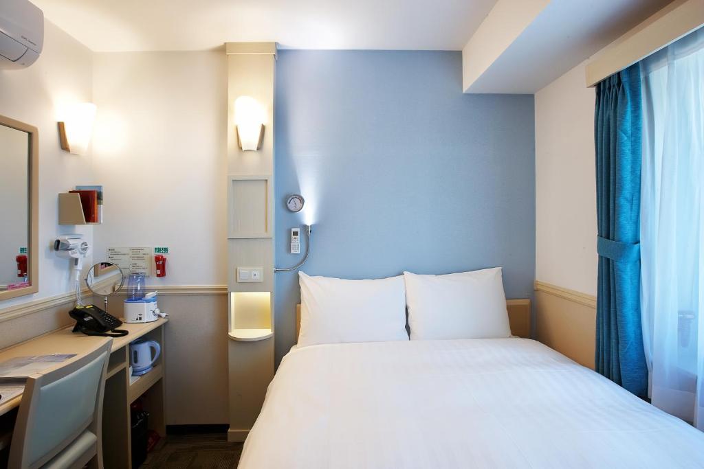 Toyoko Inn Seoul Yeongdeungpo 的客房床鋪、書桌與窗邊配置