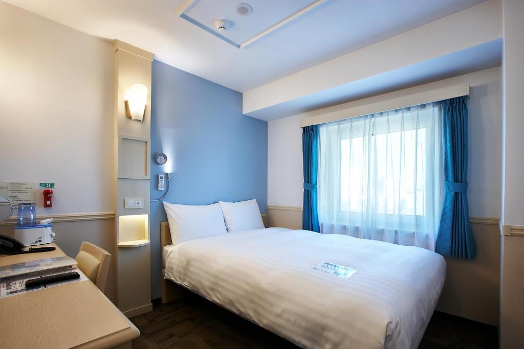 Toyoko Inn Seoul Yeongdeungpo 的另一種實際客房床鋪與窗景