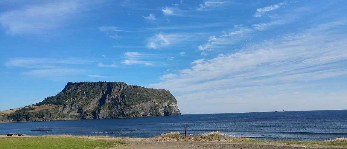 済州の海岸から見た城山日出峰の凝灰岩崖